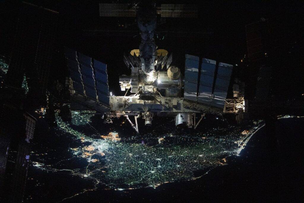 Fotografia mostra a ISS em órbita sobre a Terra durante a noite